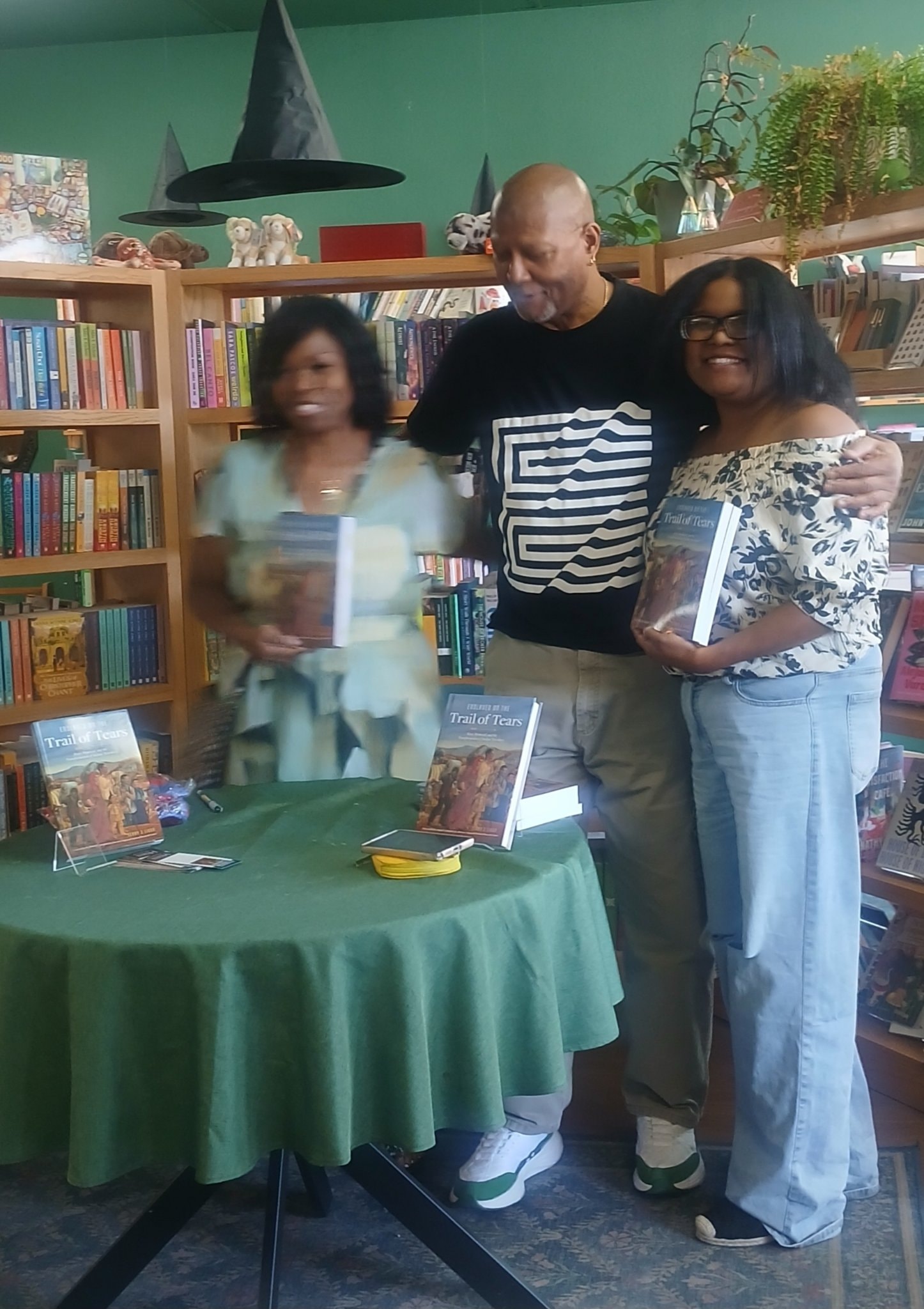 Three people holding Trail of Tears books at book signing