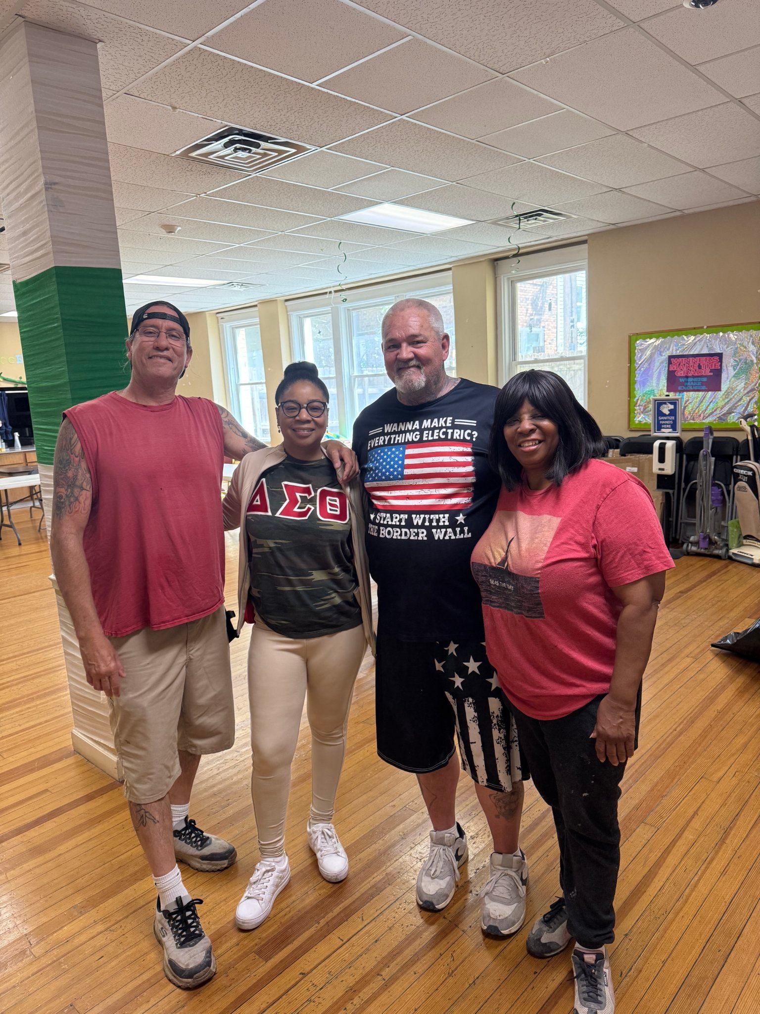 Four community members posing together in a community center