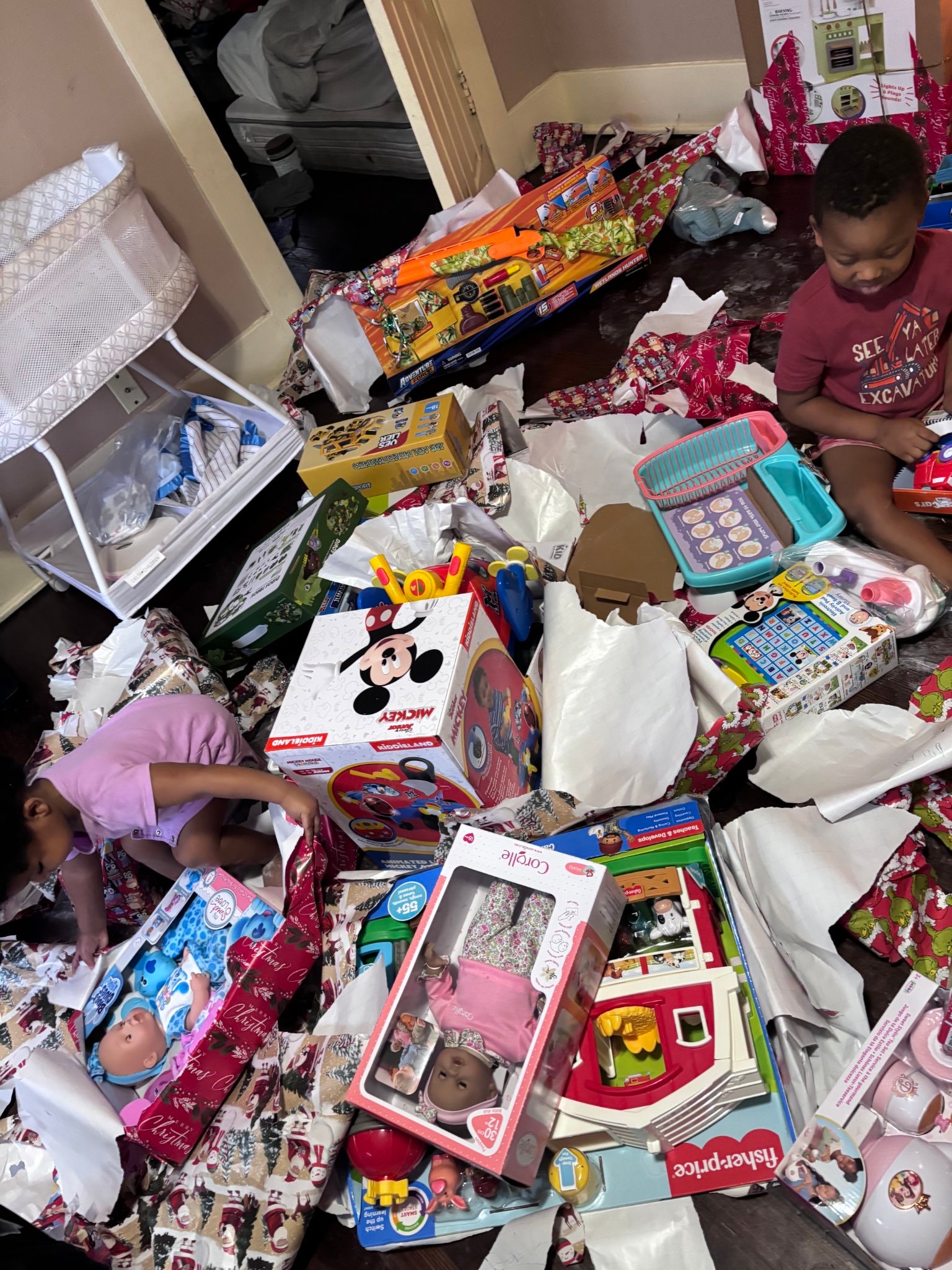 Children surrounded by Christmas toys and gifts at holiday community event