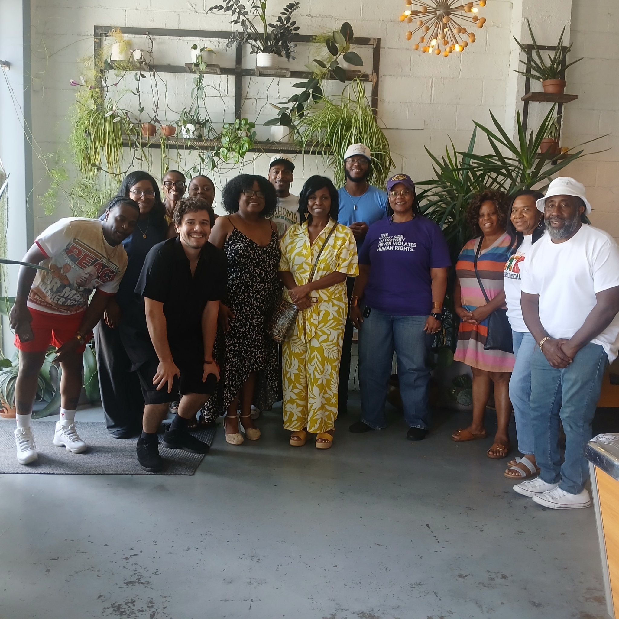 Large group photo by the plants at community gathering