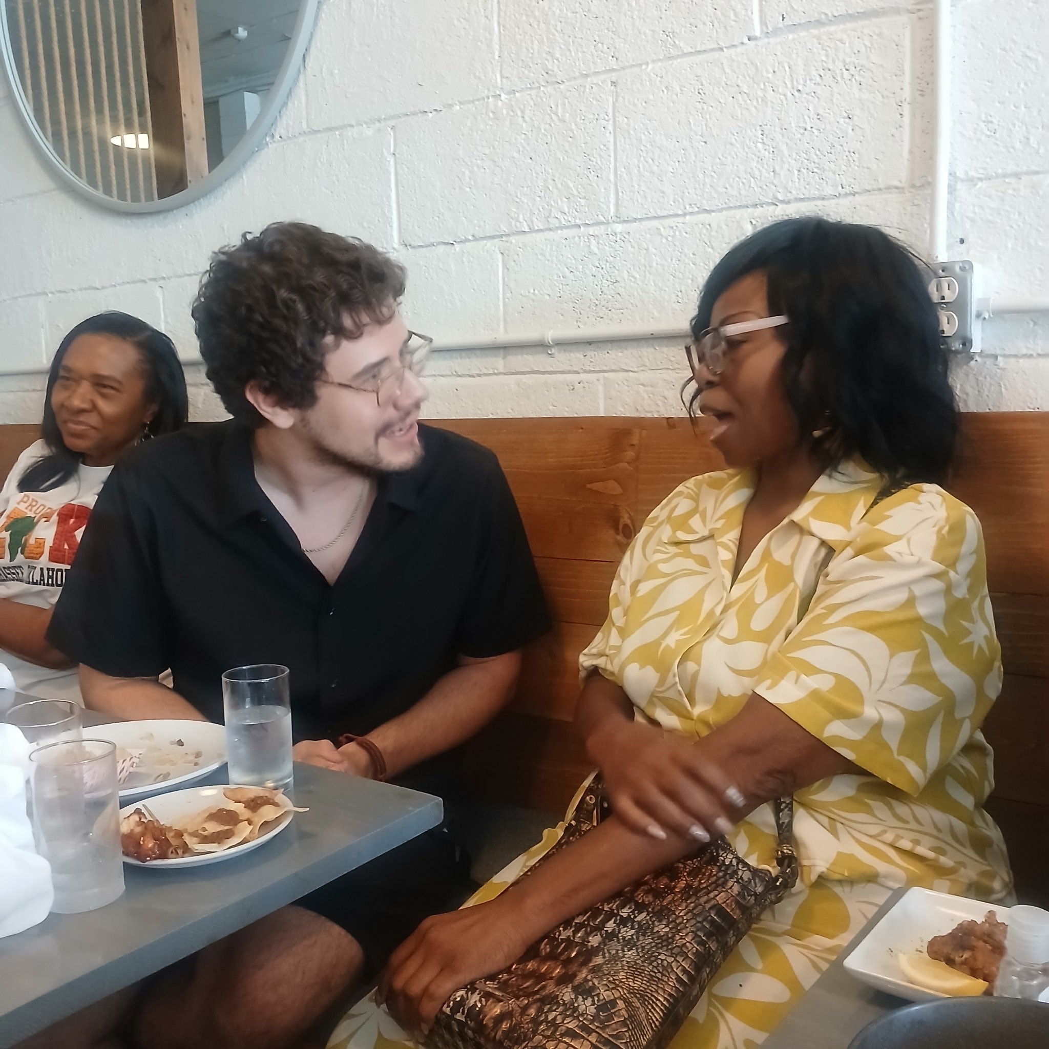 Three people in conversation at a restaurant