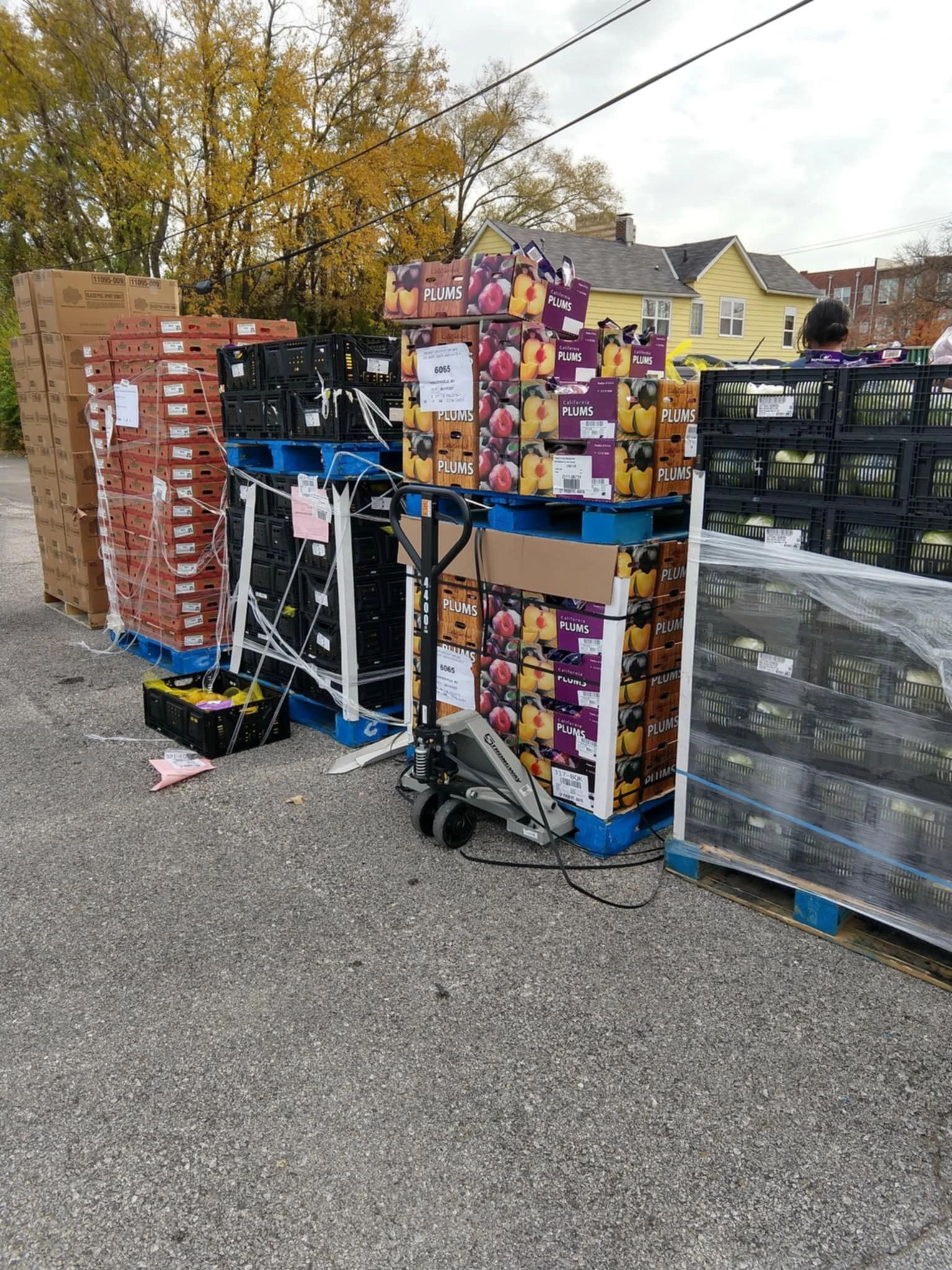 Outdoor produce distribution with pallets of plums