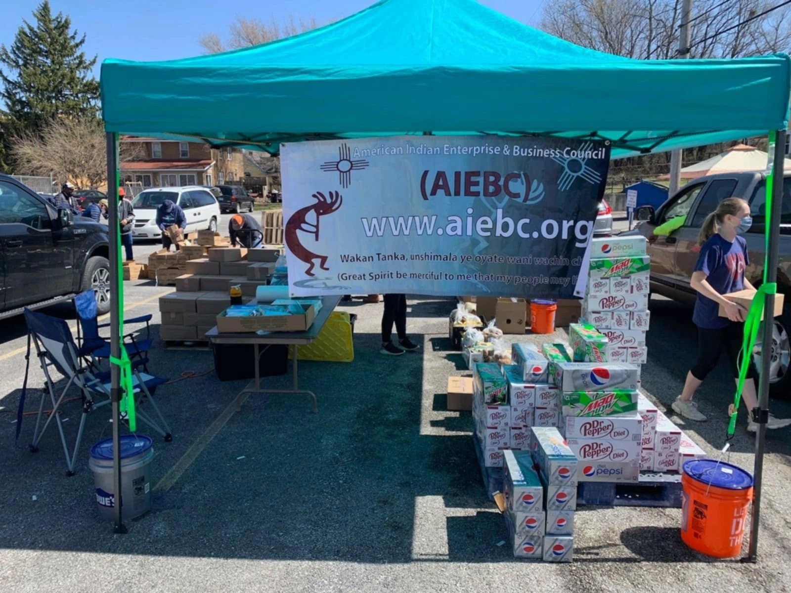 AIEBC event tent with banner and community members